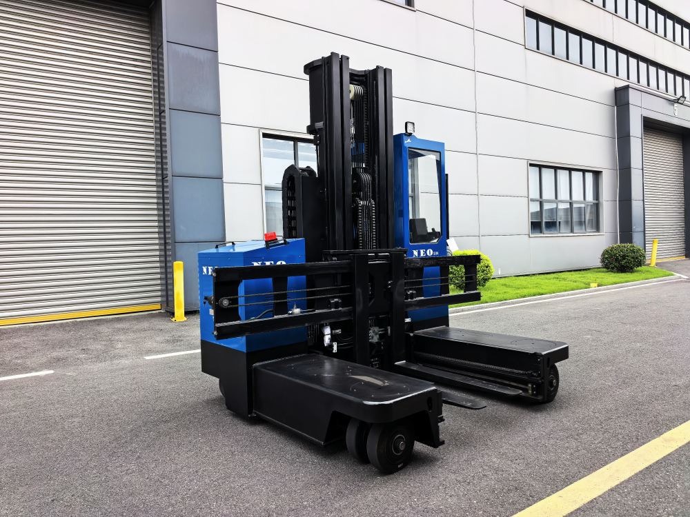 NEO FORKLIFT electric multi-directional forklift with tall mast in front of a factory building NEO FORKLIFT electric multi-directional forklift with tall mast in front of a factory building