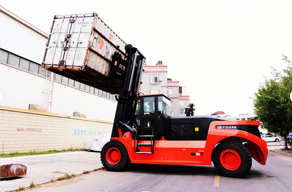 Heavy-duty diesel forklift lifting a shipping container at an angle in an industrial yard
